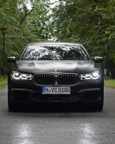 Ένα BMW αυτοκίνητο που βρίσκεται στη μέση ενός δρόμου σε δάσος
