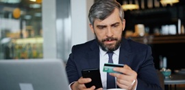 Ένας άνδρας μπροστά σε υπολογιστή έτοιμος να κάνει ηλεκτρονική αγορά