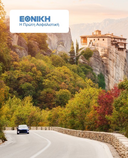 Αυτοκίνητο στρίβει σε ανηφόρα με φόντο δάσος και ένα κτήριο πάνω σε βουνό με λογότυπο της Εθνικής