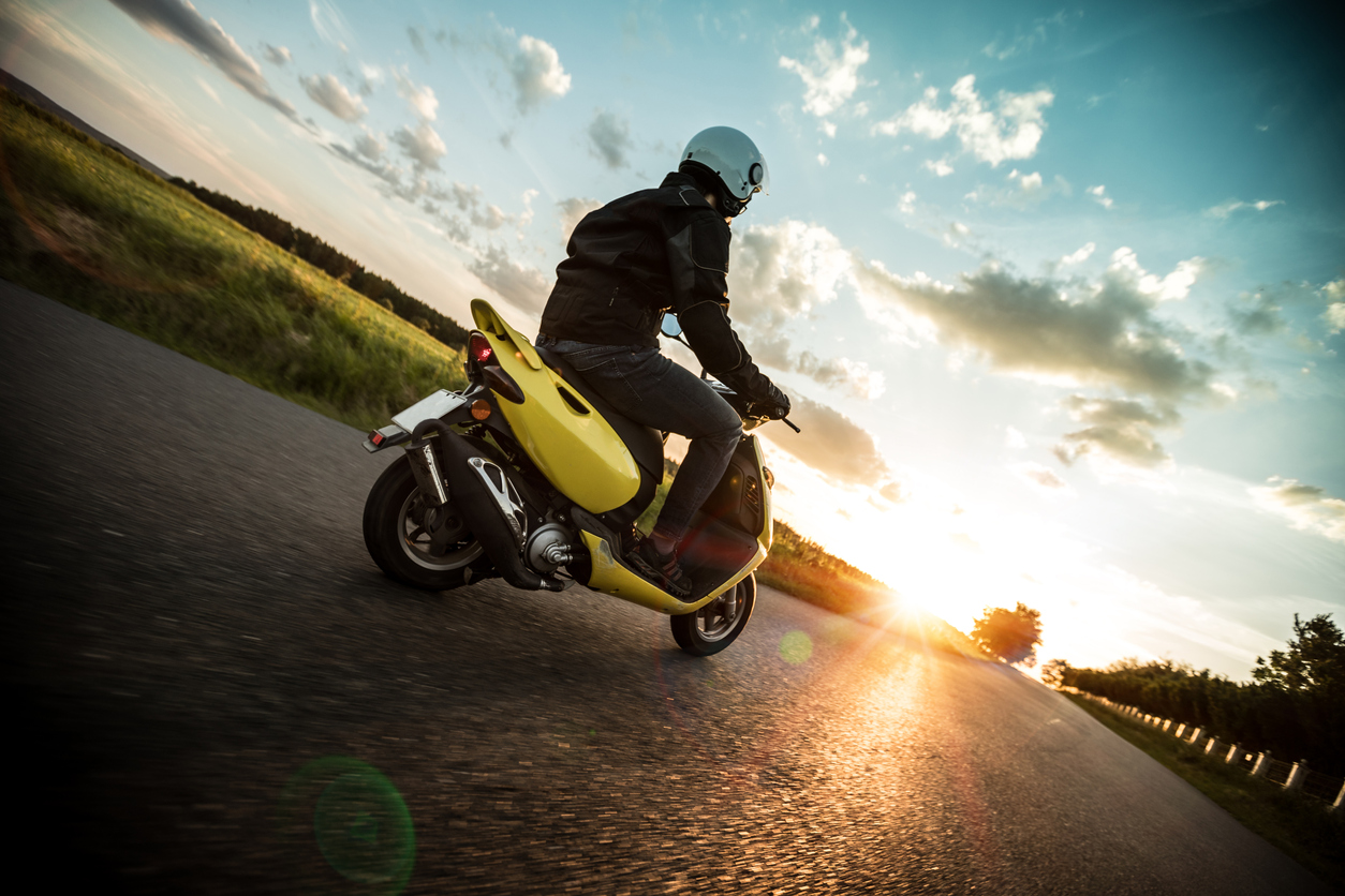 Κίτρινο scooter κατευθείνεται προς το ηλιοβασίλεμα